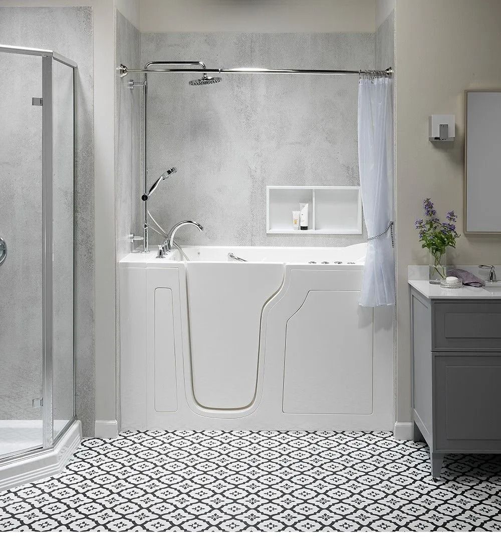 A white walk-in bathtub with an integrated door, shower head, and faucet, installed in a bathroom with patterned tile.