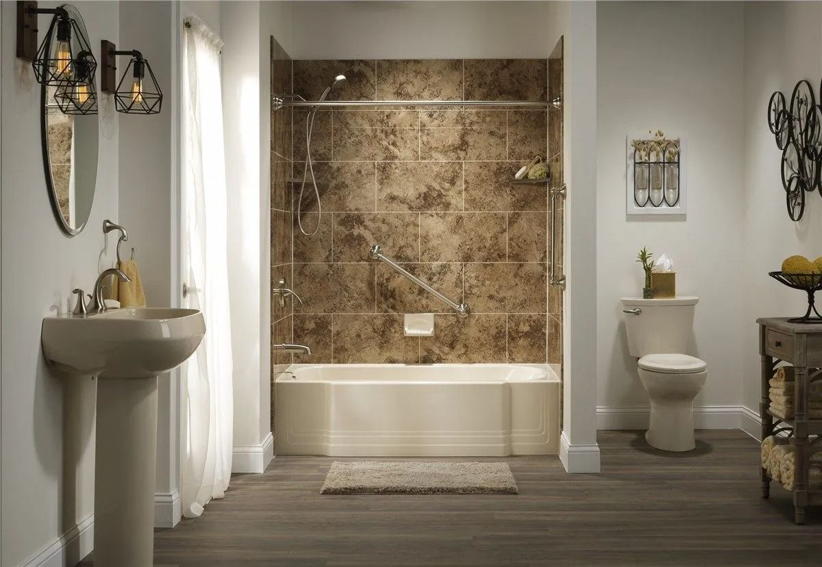 A modern bathroom featuring a pedestal sink, a toilet, and a bathtub with brown stone-patterned tile walls.