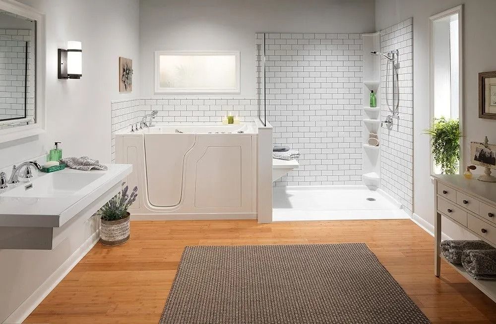A bright, modern bathroom featuring a white walk-in bathtub, a walk-in shower with subway tile, a sink, and wood flooring.