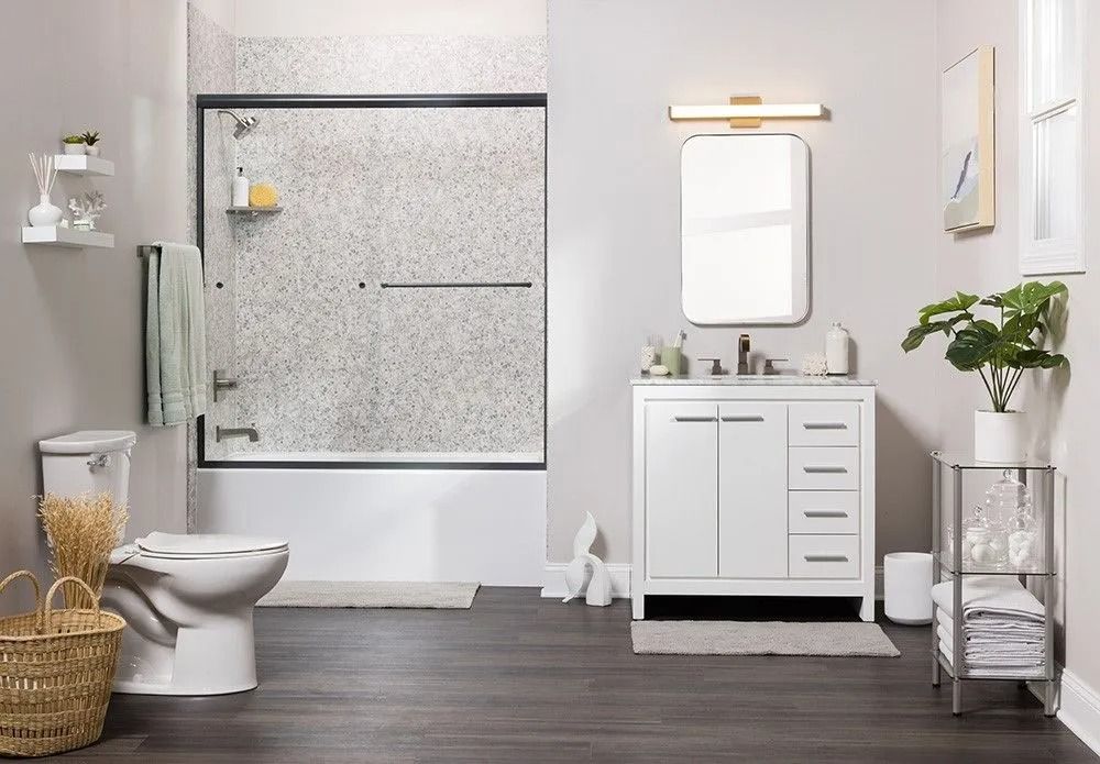 Modern bathroom featuring a white vanity, a toilet, a bathtub with a glass door, and dark wood-look flooring.