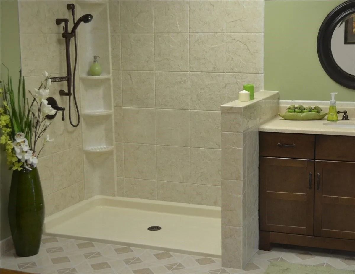 A bathroom featuring a walk-in shower with tiled walls and built-in shelving next to a dark wood vanity and round mirror.