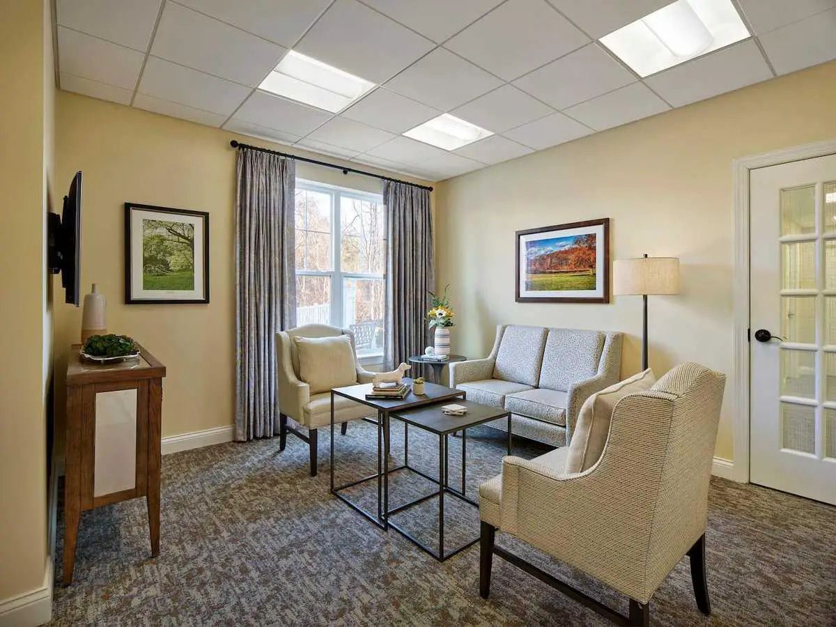 A living room with a couch , chairs , a table and a television.