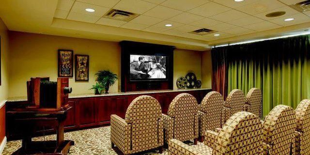 A movie theater with chairs and a flat screen tv.