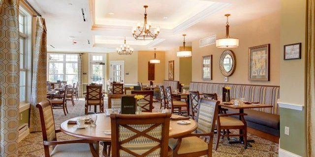 A large dining room with tables and chairs and a clock on the wall.
