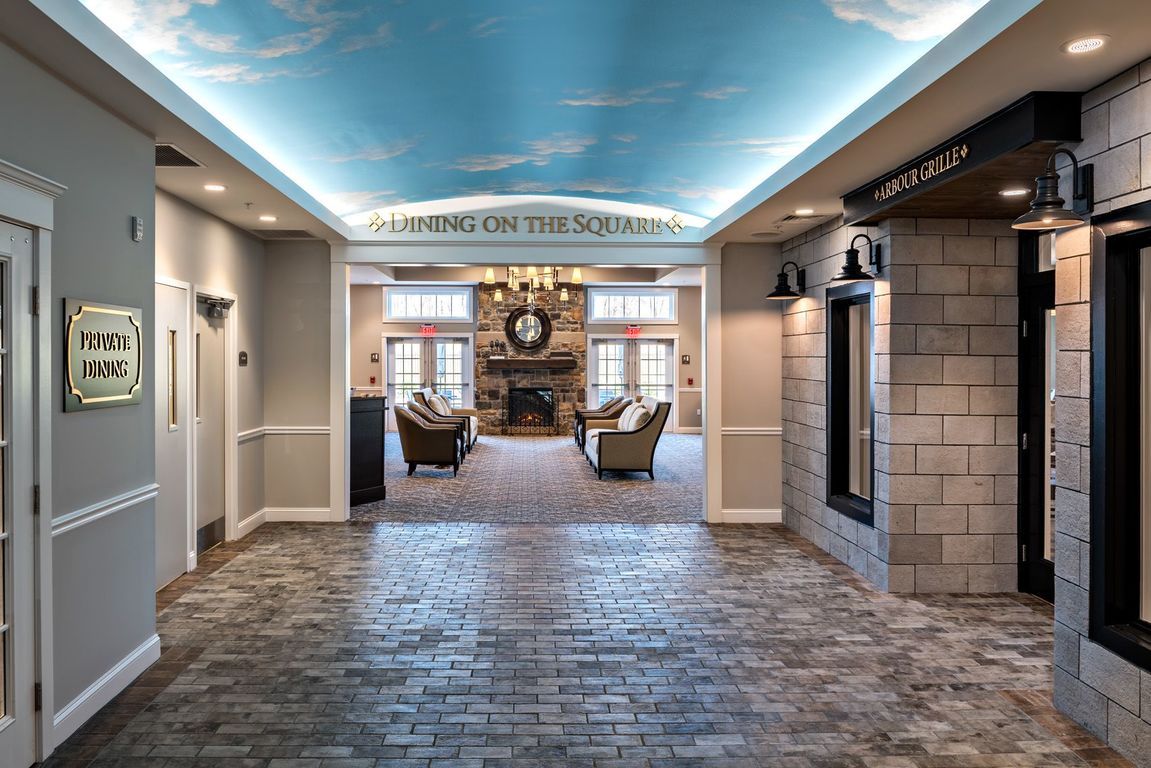 A hallway with a brick floor and a blue sky ceiling.