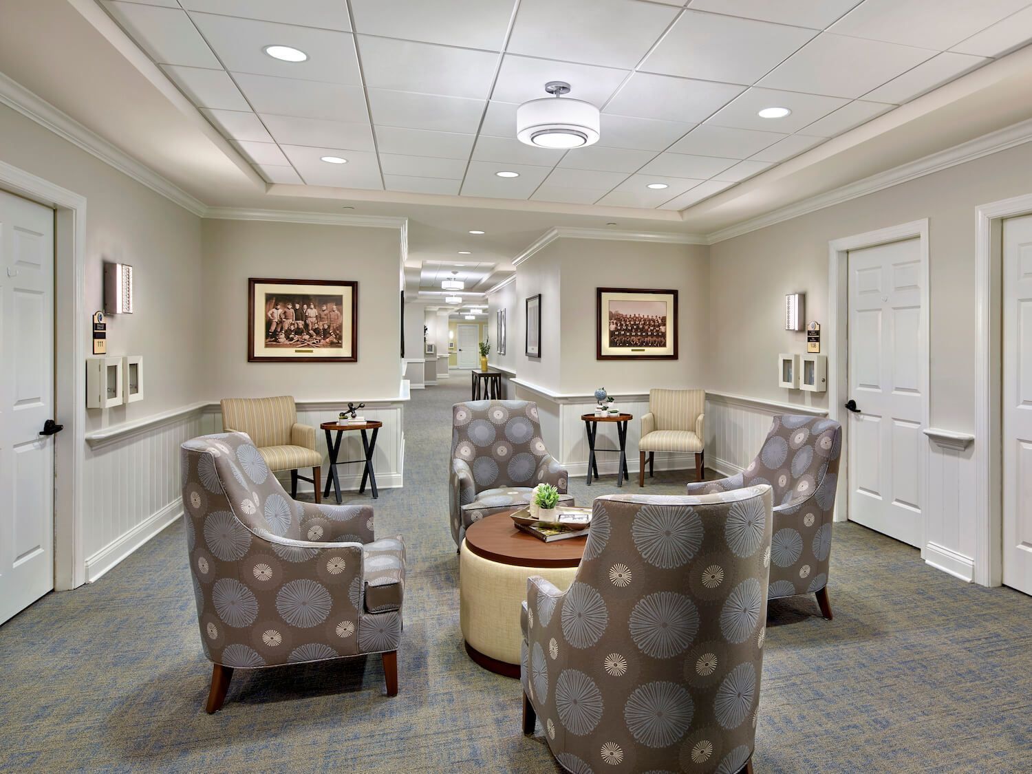 There are many chairs and tables in this hallway.