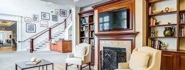 A living room with a fireplace , chairs , a table and a television.