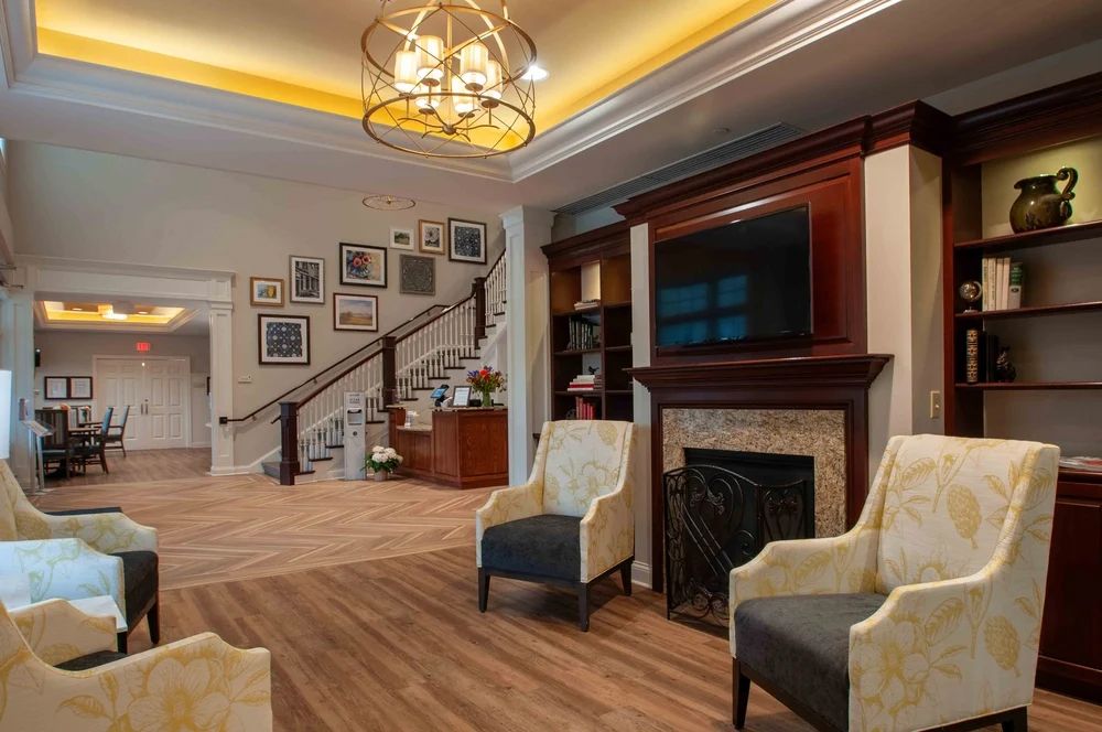 A living room with chairs , a fireplace and a television.