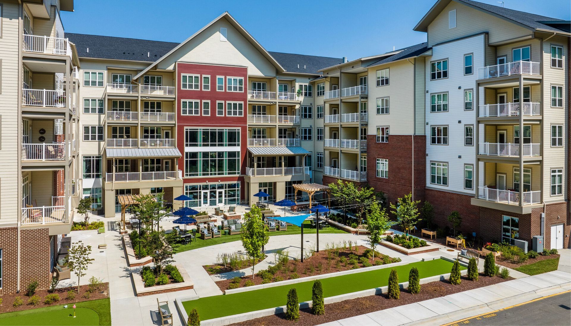 An aerial view of a large apartment building with a pool in the middle of it.