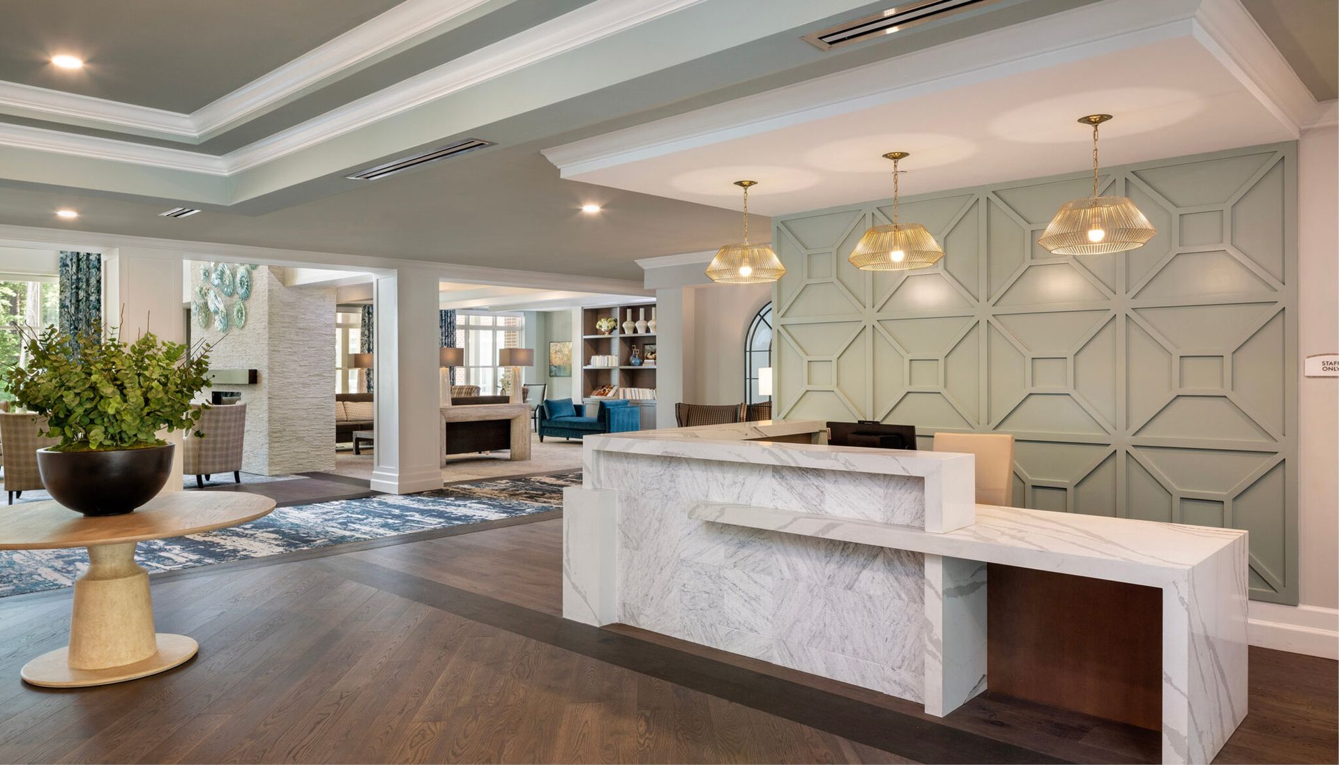 A hotel lobby with a marble counter and a table.