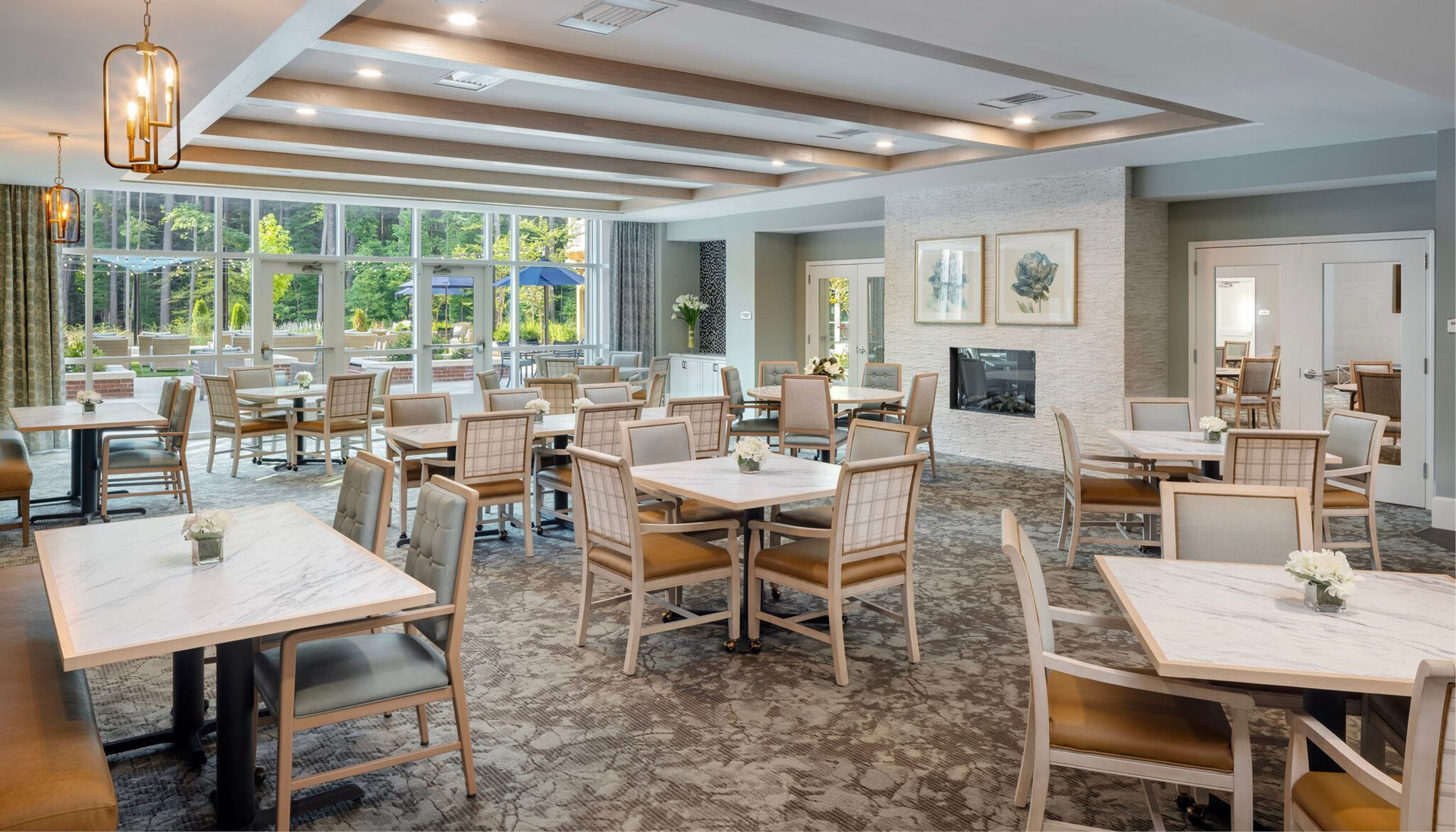 A large dining room with tables and chairs and a fireplace.
