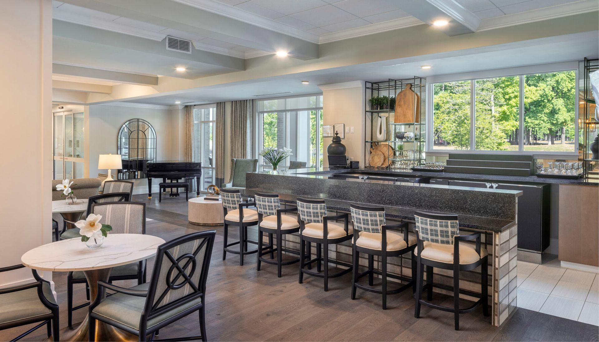 A large room with tables and chairs and a bar.