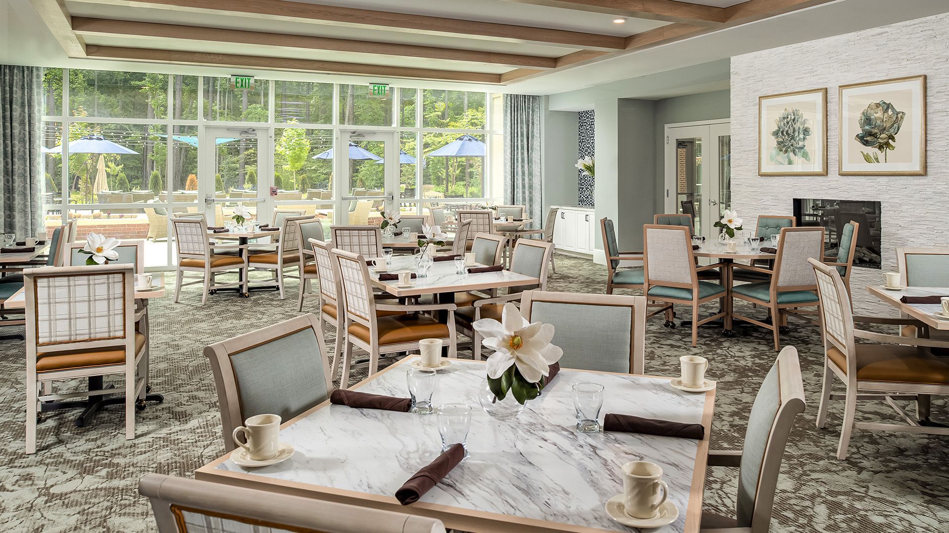 A large dining room with tables and chairs and a fireplace.