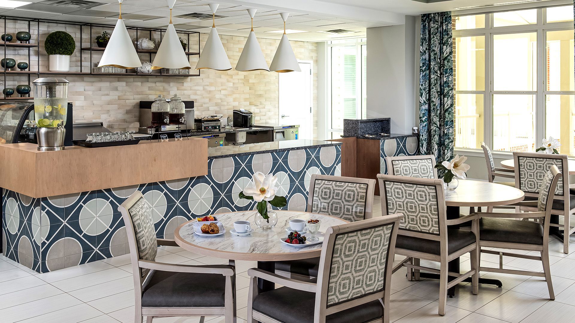 A restaurant with tables and chairs and a counter.