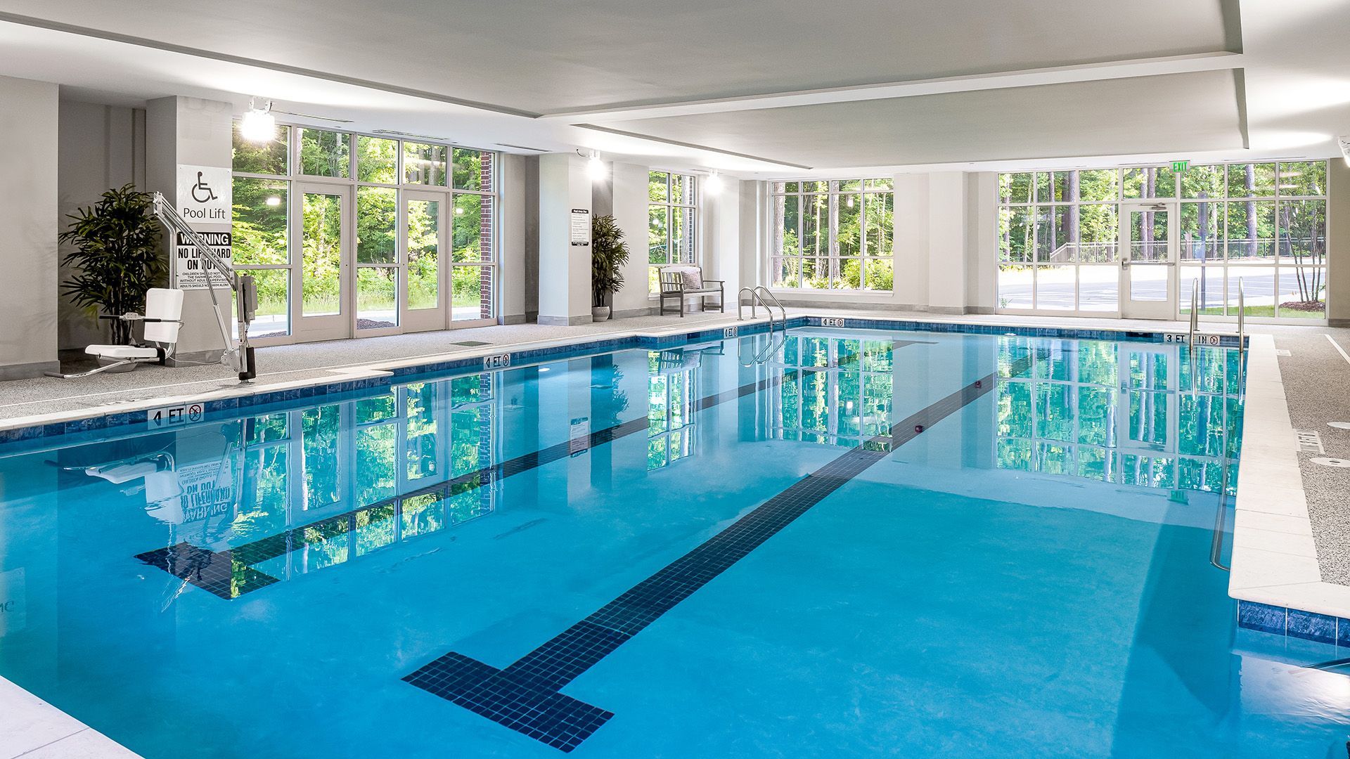 A large indoor swimming pool with a lot of windows