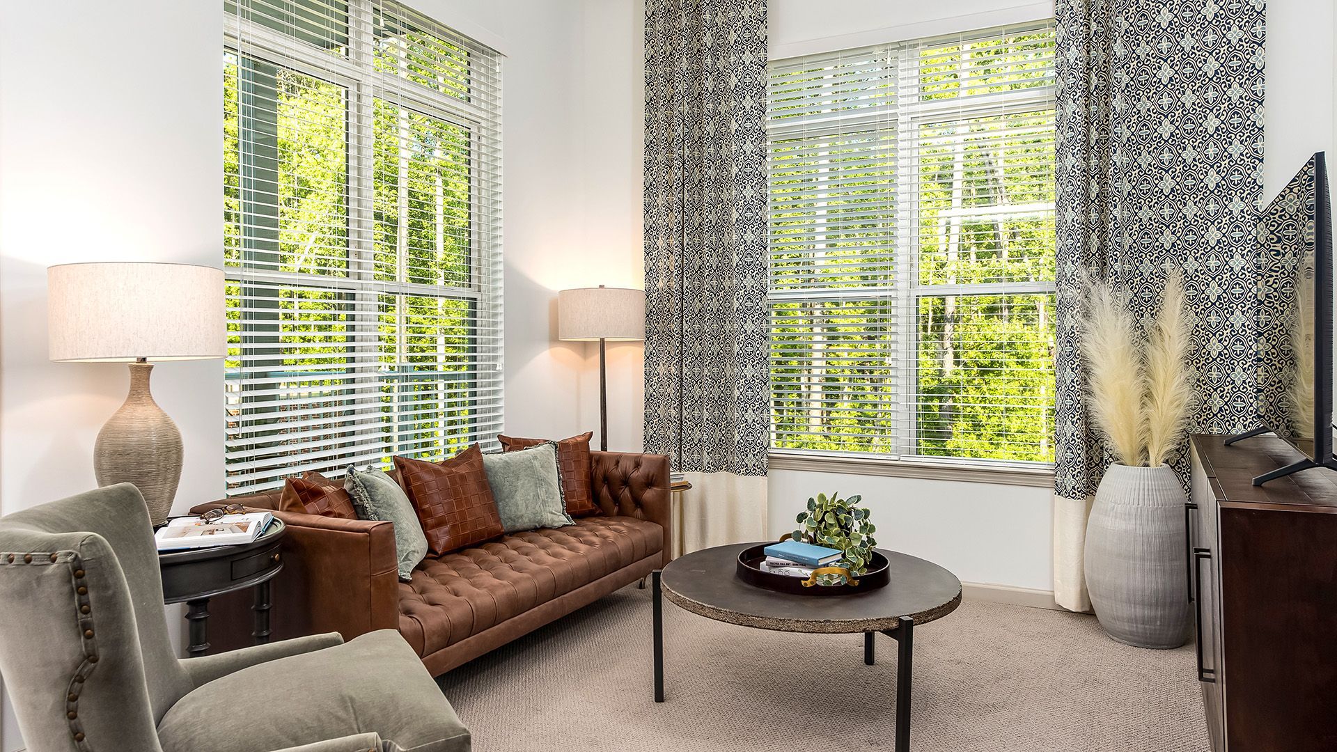 A living room with a couch , chair , coffee table and television.