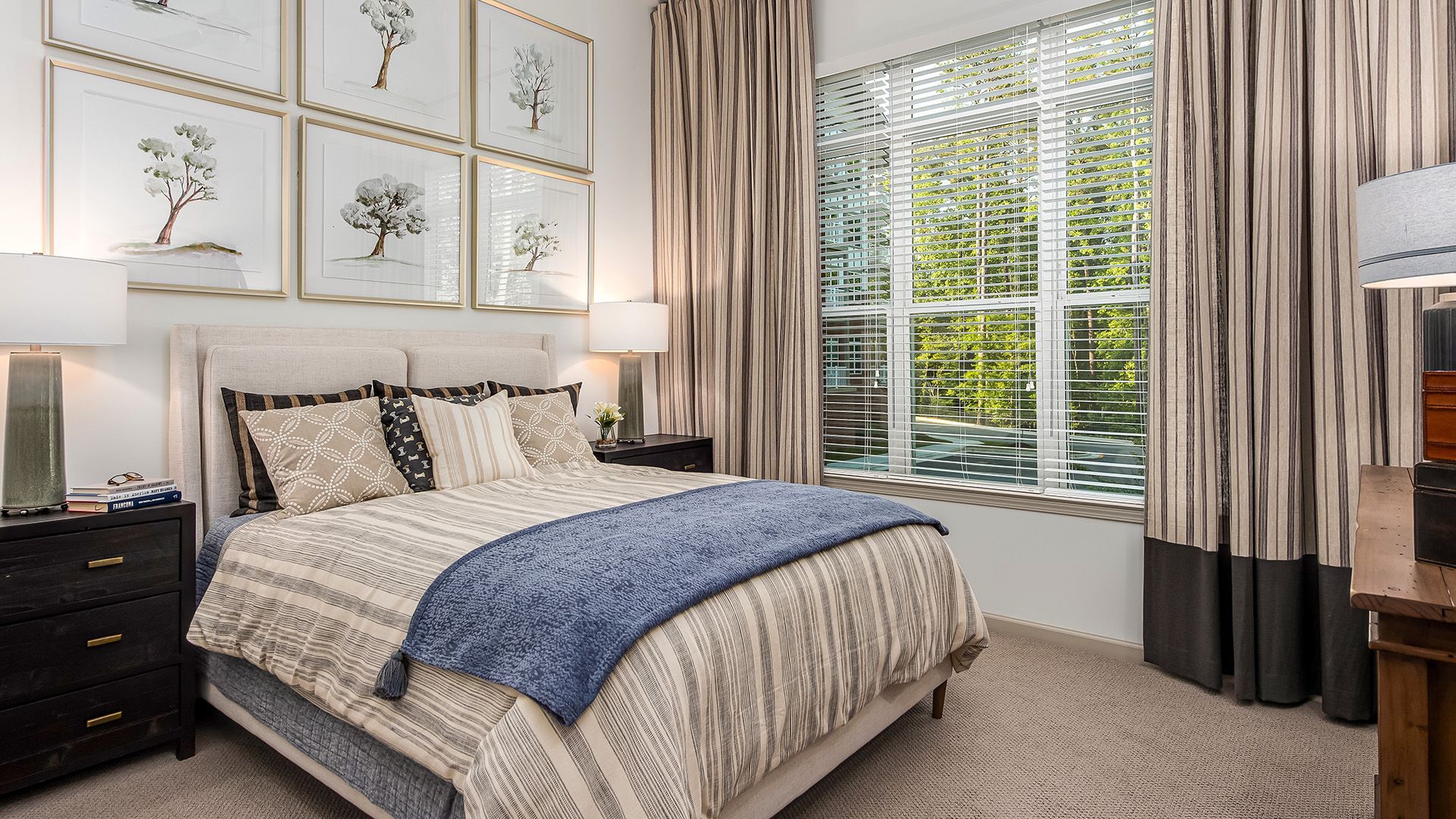 A bedroom with a bed , dresser , nightstand , and two windows.