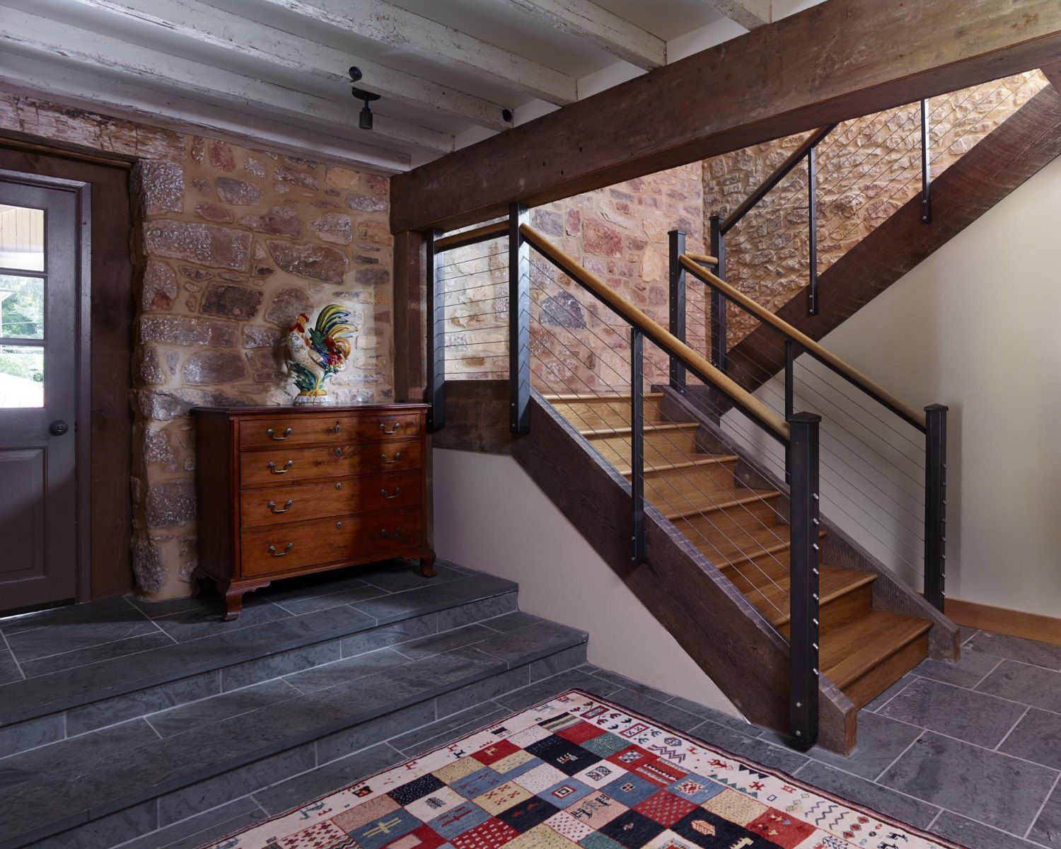 A wooden staircase with a glass railing in a hallway