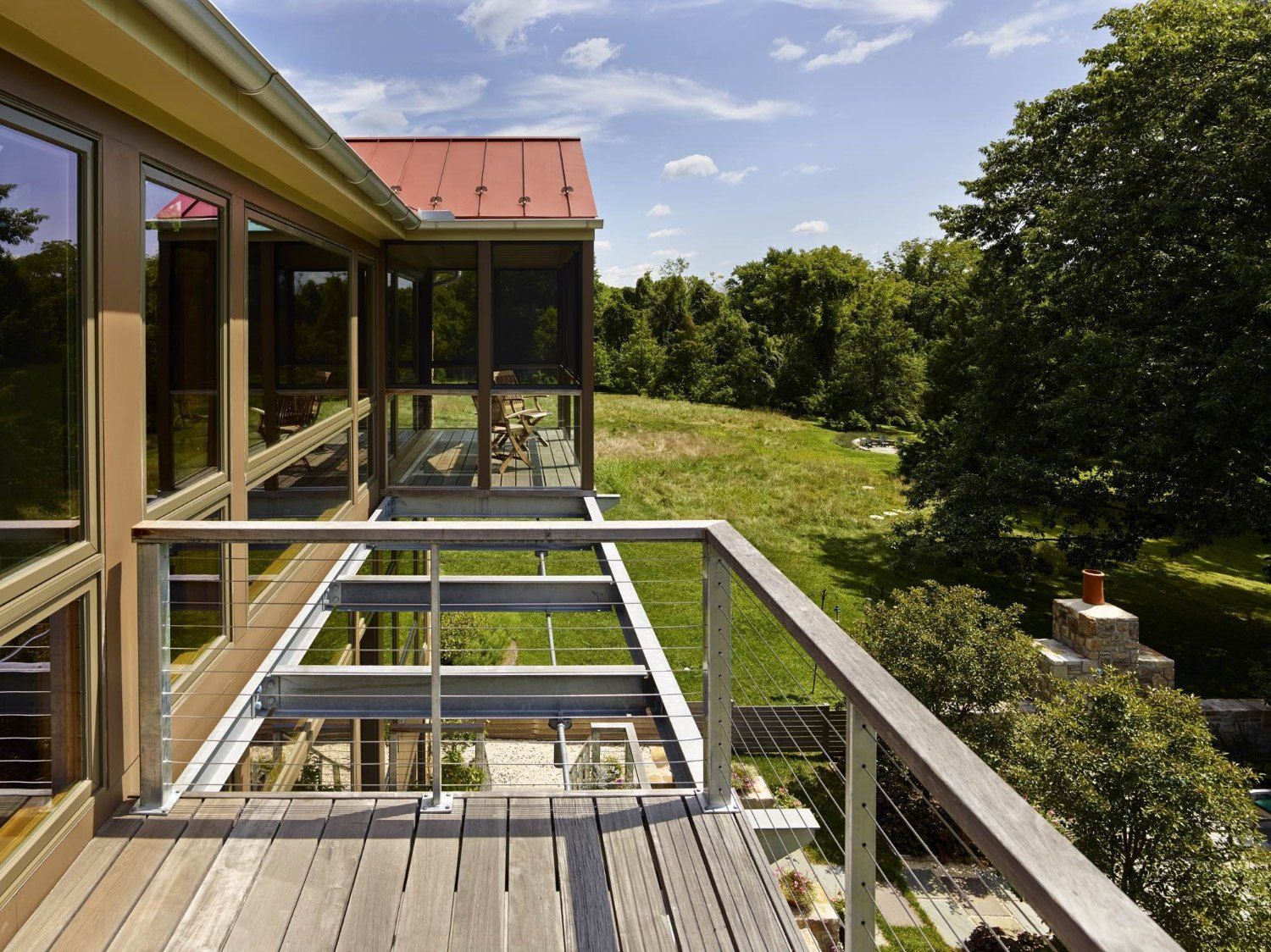 A house with a red roof and a wooden deck