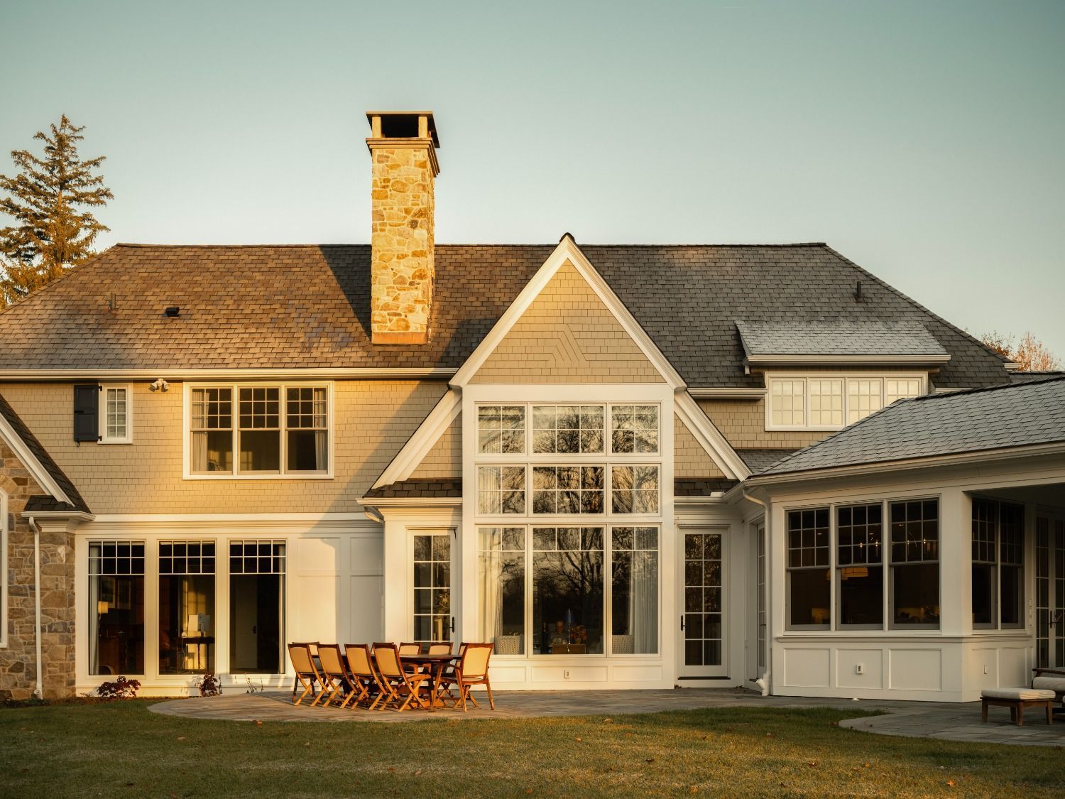 A large house with a lot of windows and a chimney.