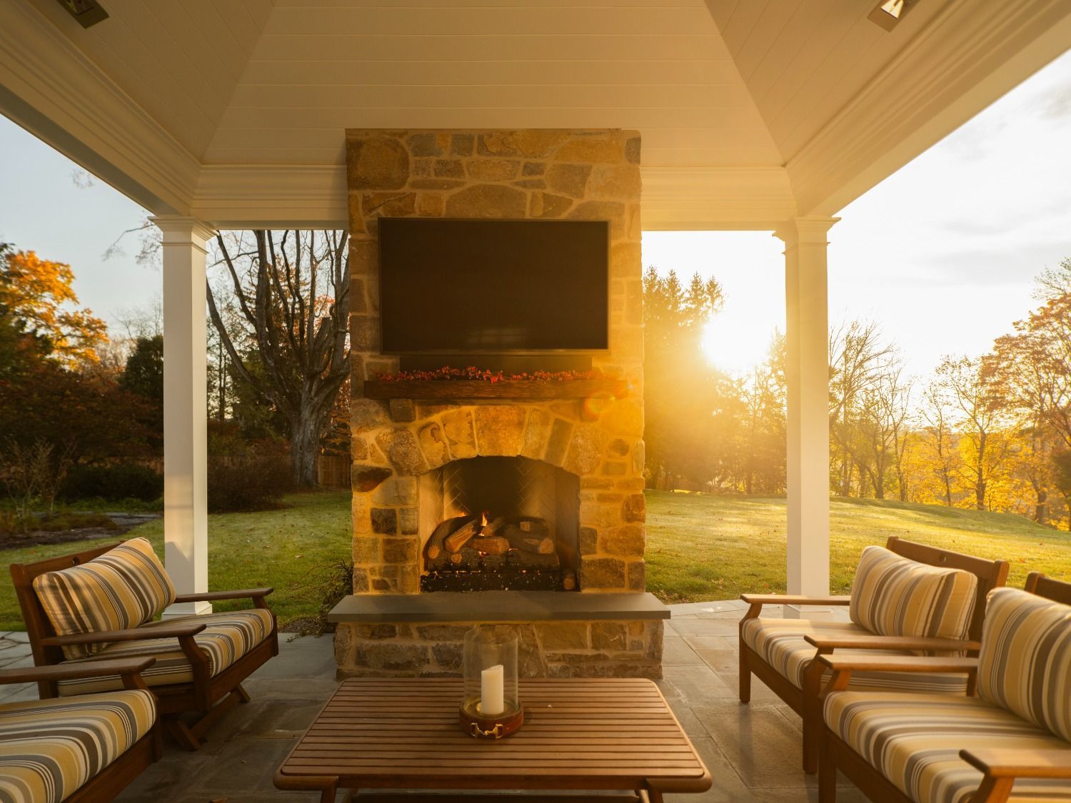A patio with a fireplace and a flat screen tv.