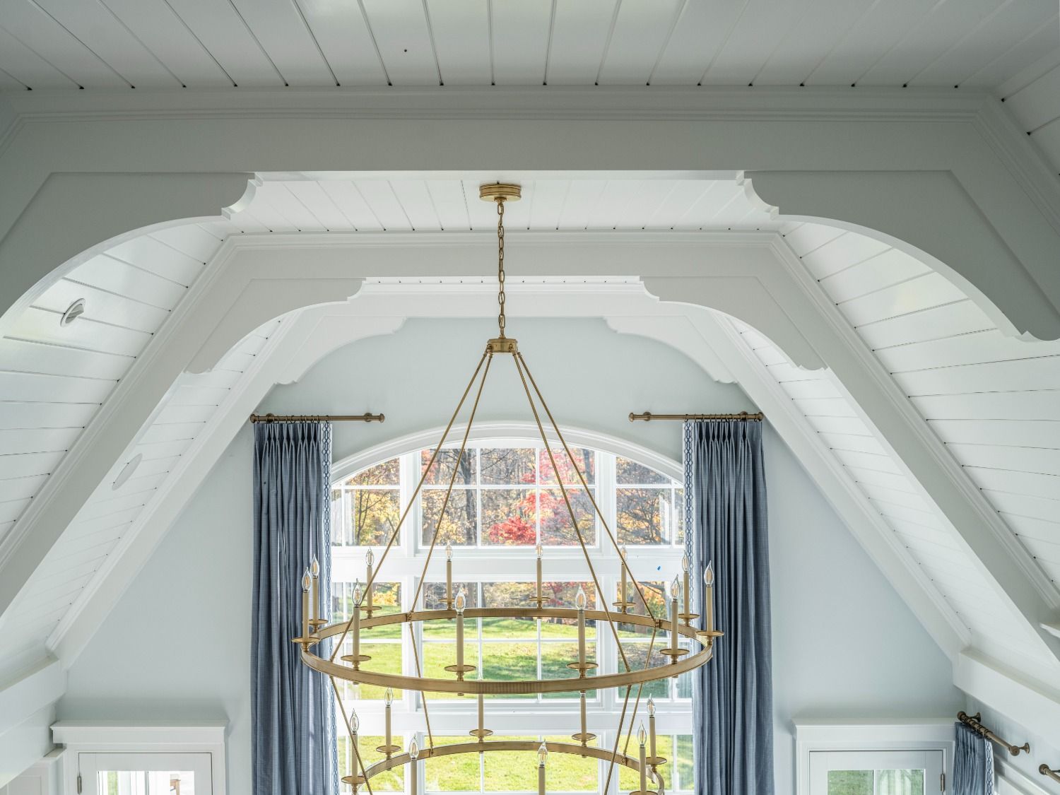 A large chandelier is hanging from the ceiling in a room with a window.