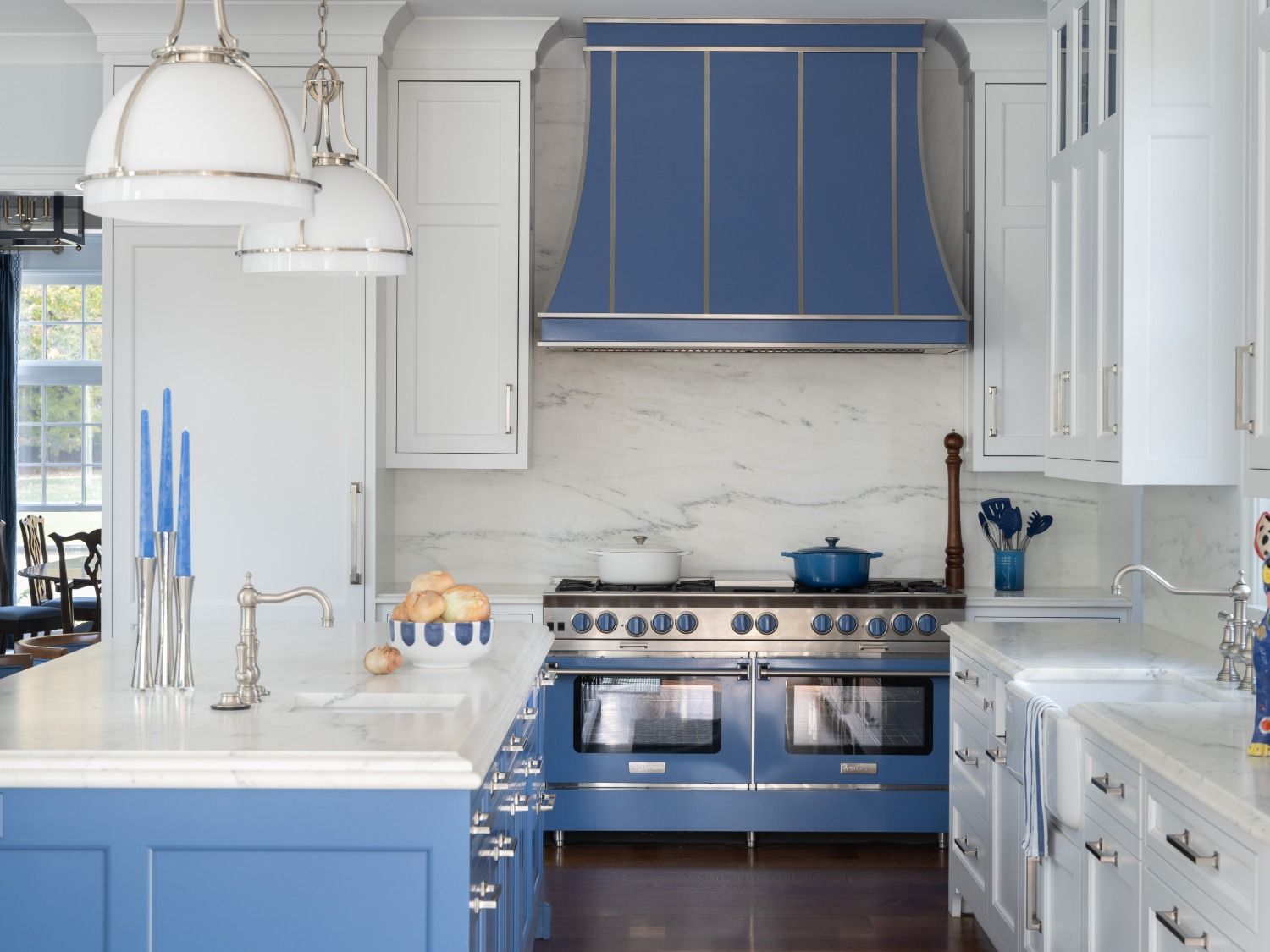 A kitchen with blue cabinets and a blue stove top oven.