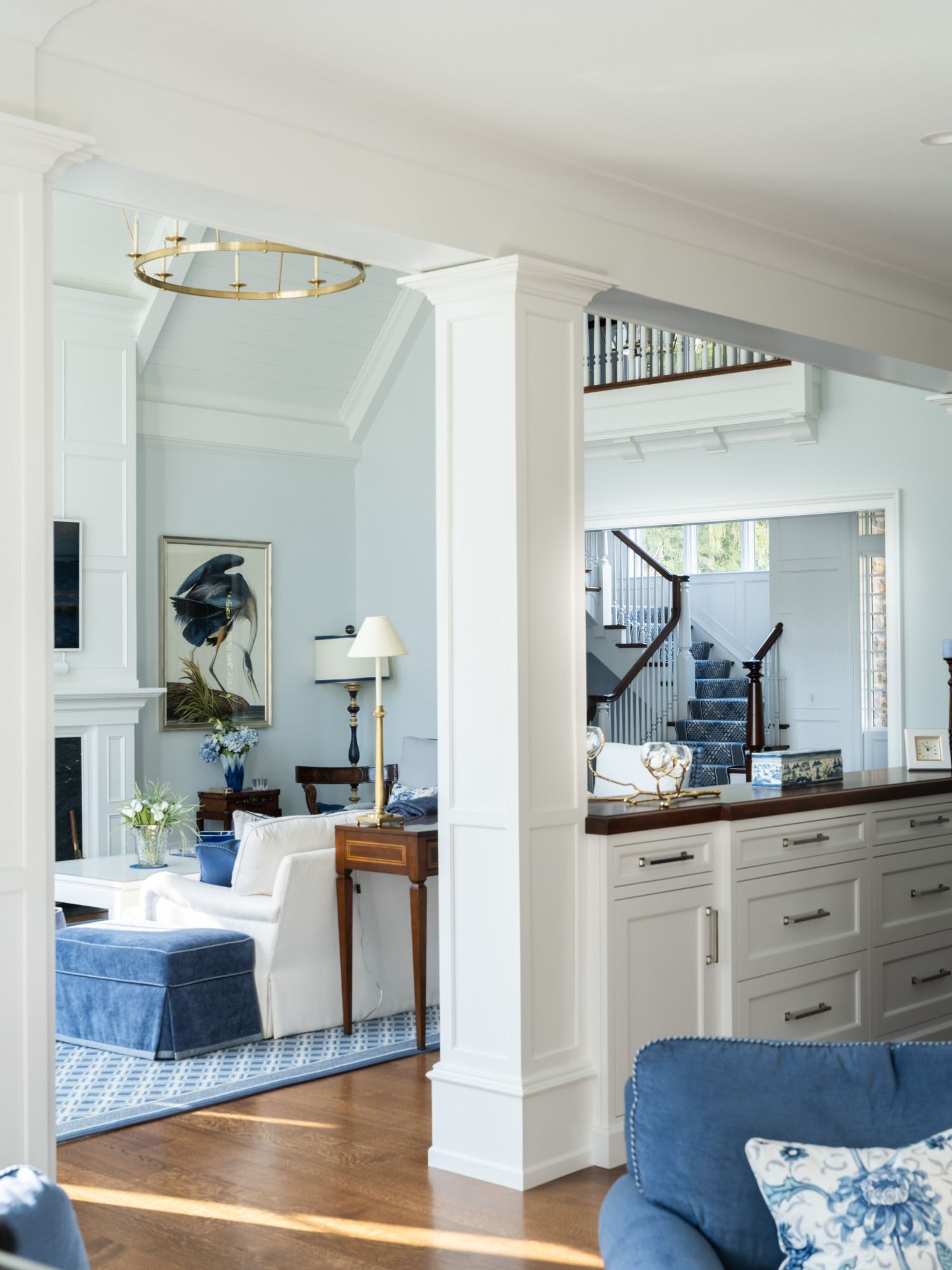 A living room with a blue chair and white furniture