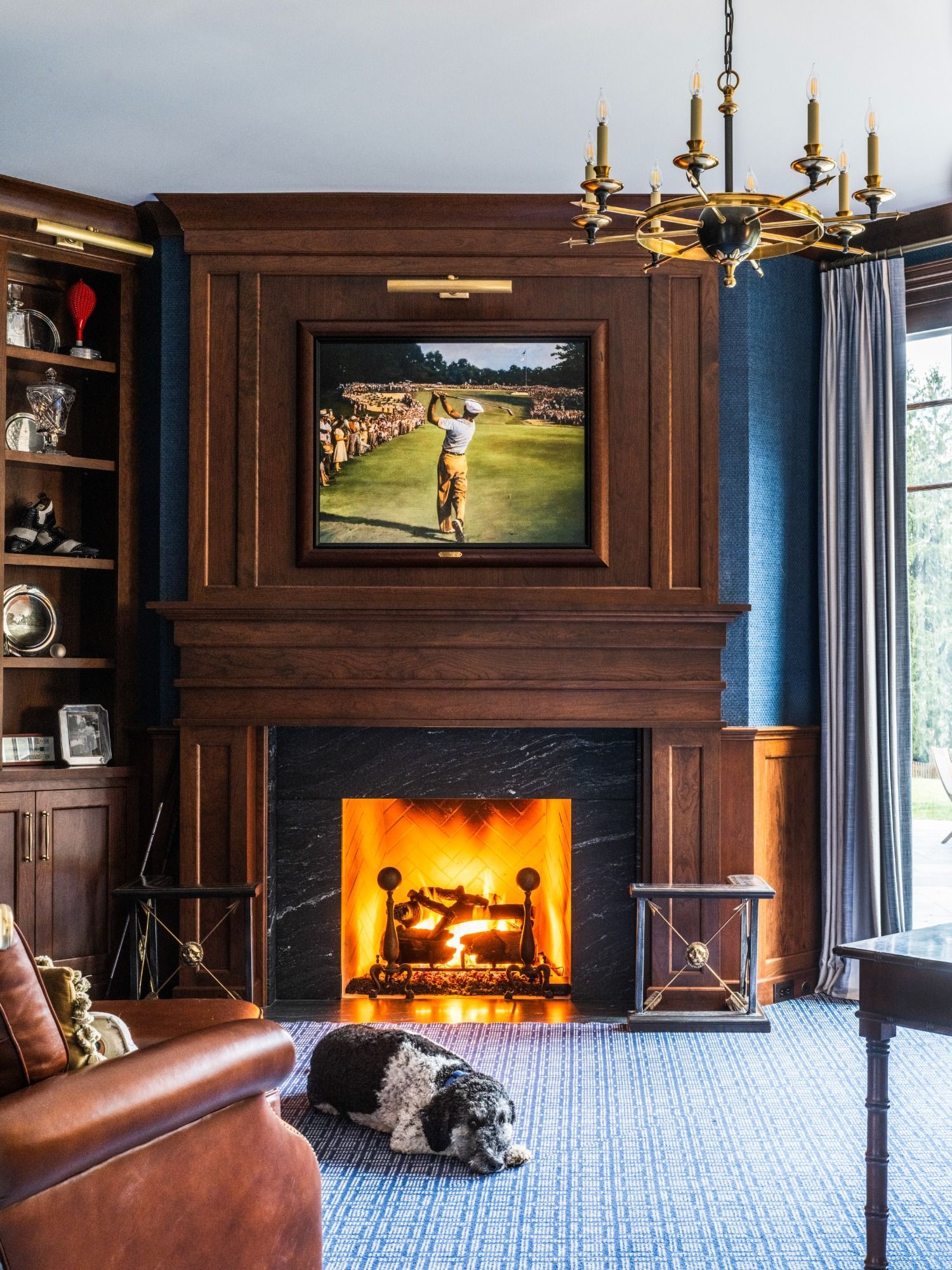 A dog is laying in front of a fireplace in a living room