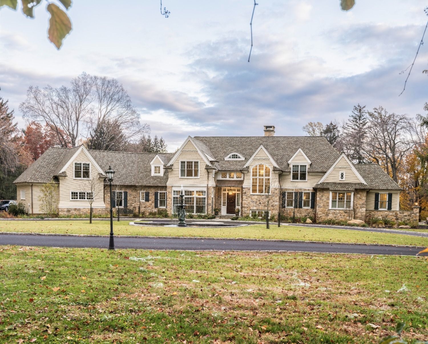 A large house with a lot of windows is sitting on top of a lush green field.