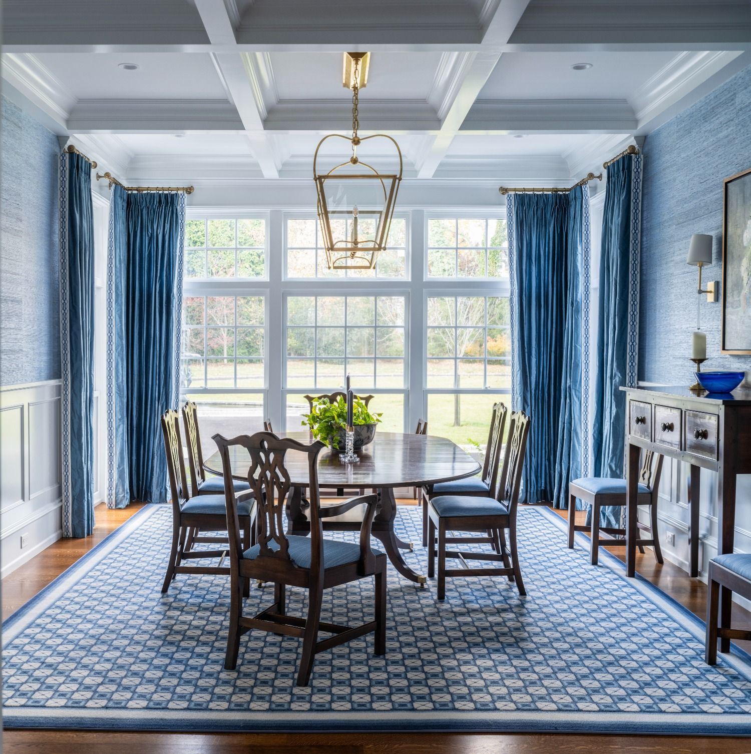 A dining room with a table and chairs and blue curtains