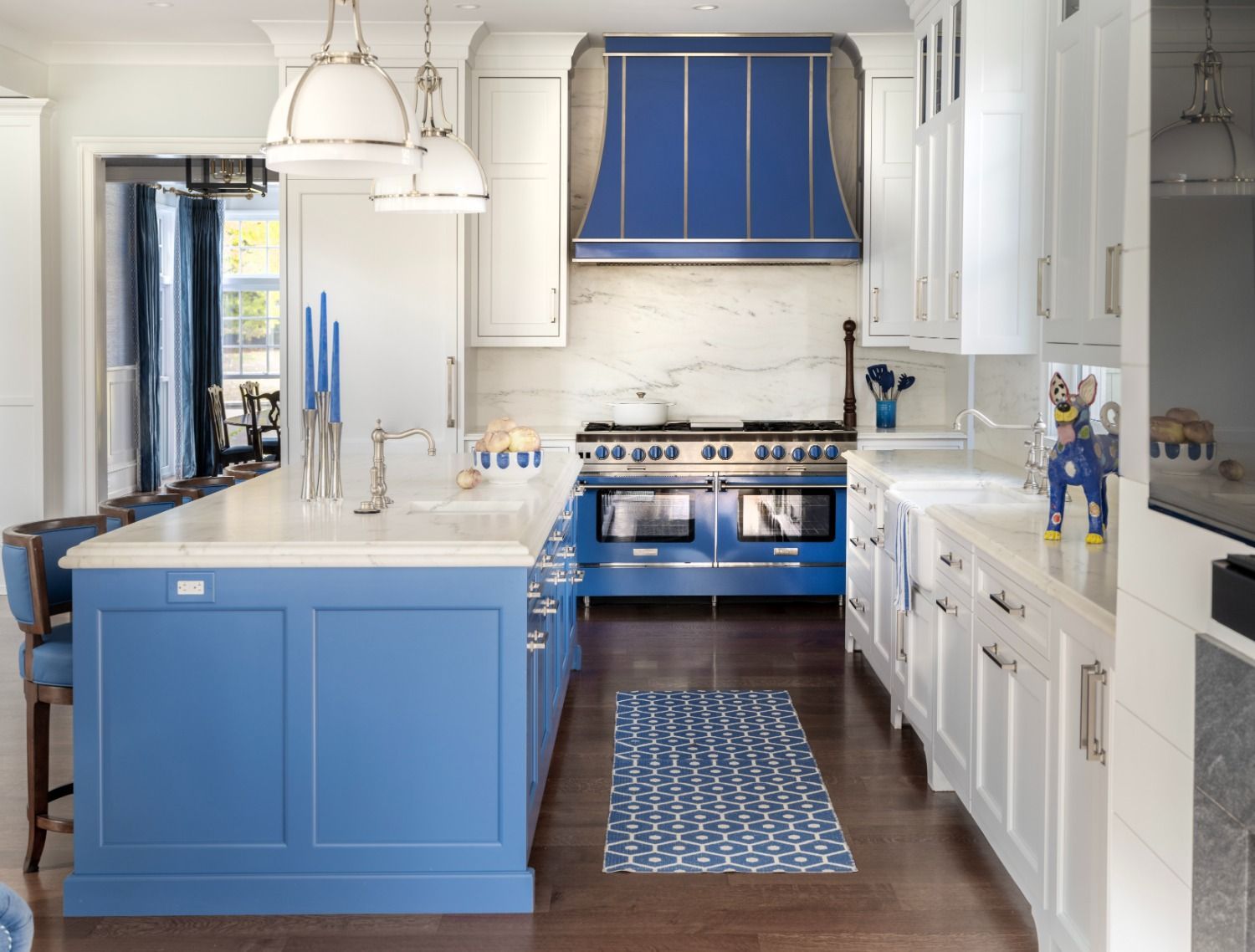 A kitchen with blue cabinets , white cabinets , and a blue stove top oven.