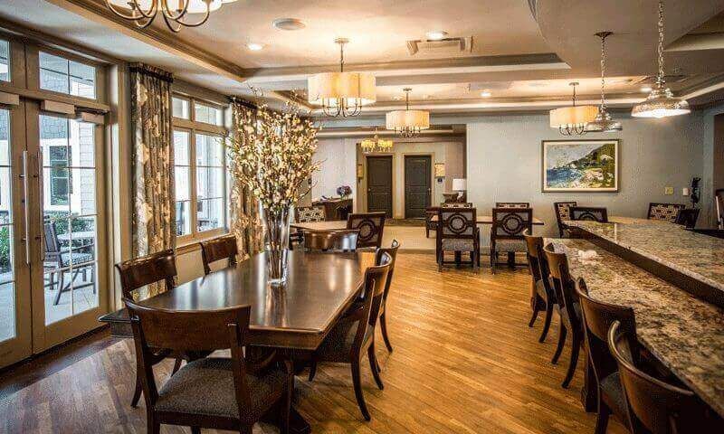 A large dining room with tables and chairs and a bar.