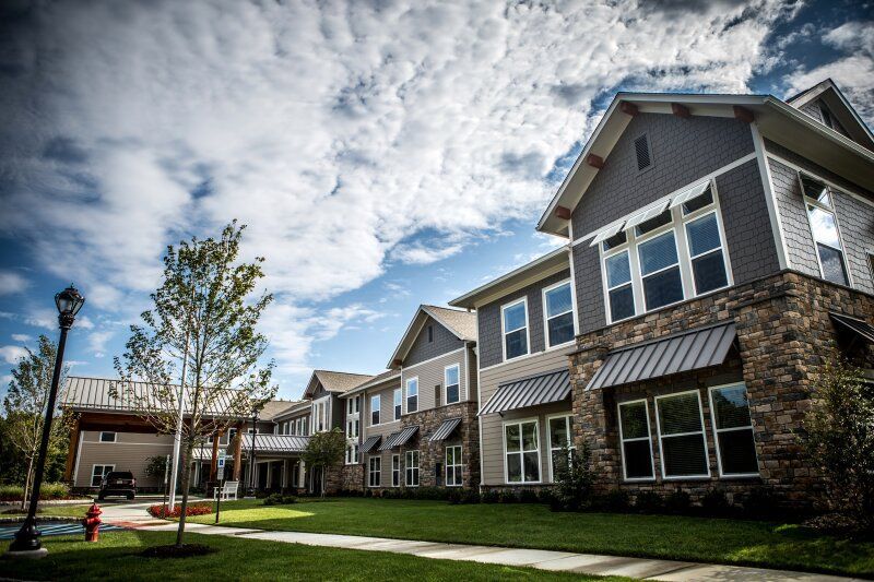 A large apartment building with a lot of windows and a fire hydrant in front of it.