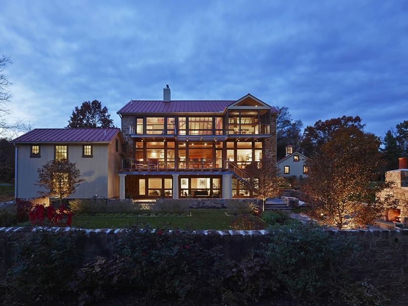 A large house with a lot of windows is lit up at night