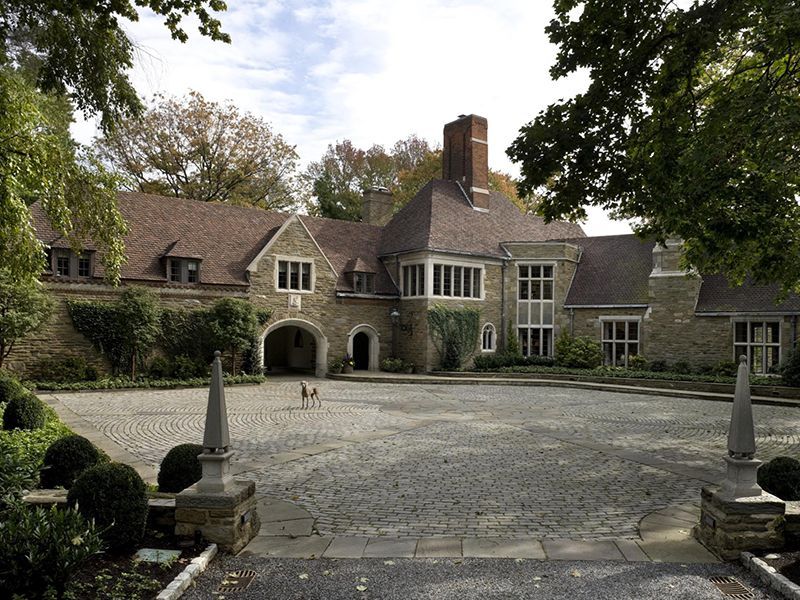 A large stone house with a driveway leading to it