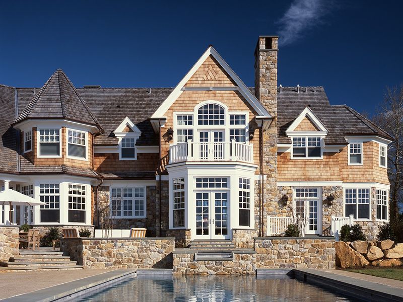 A large house with a swimming pool in front of it