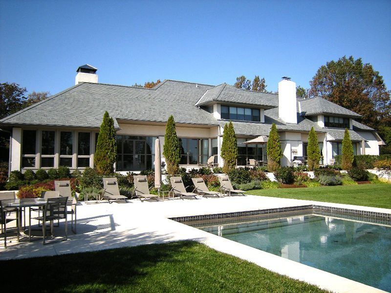 A large house with a large swimming pool in front of it