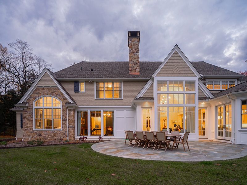 A large house with a patio and a table and chairs in front of it.