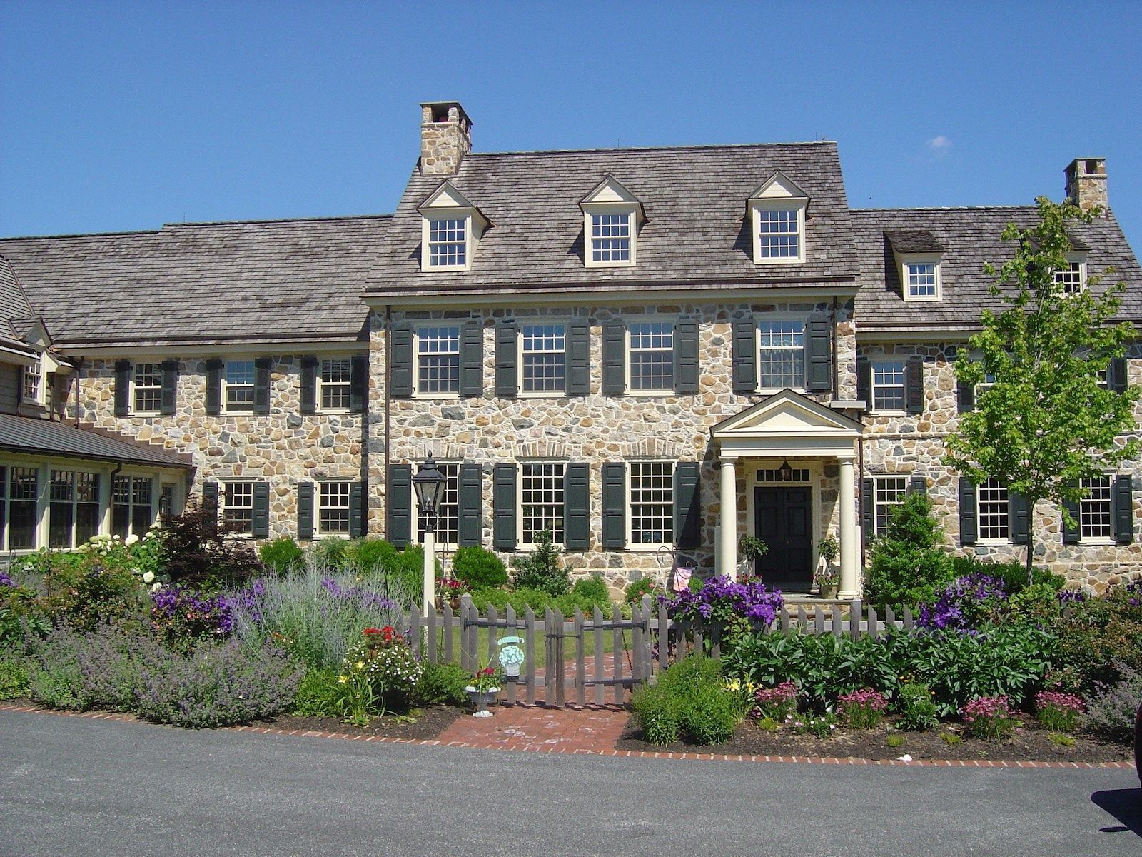 A large stone house with a lot of windows and shutters