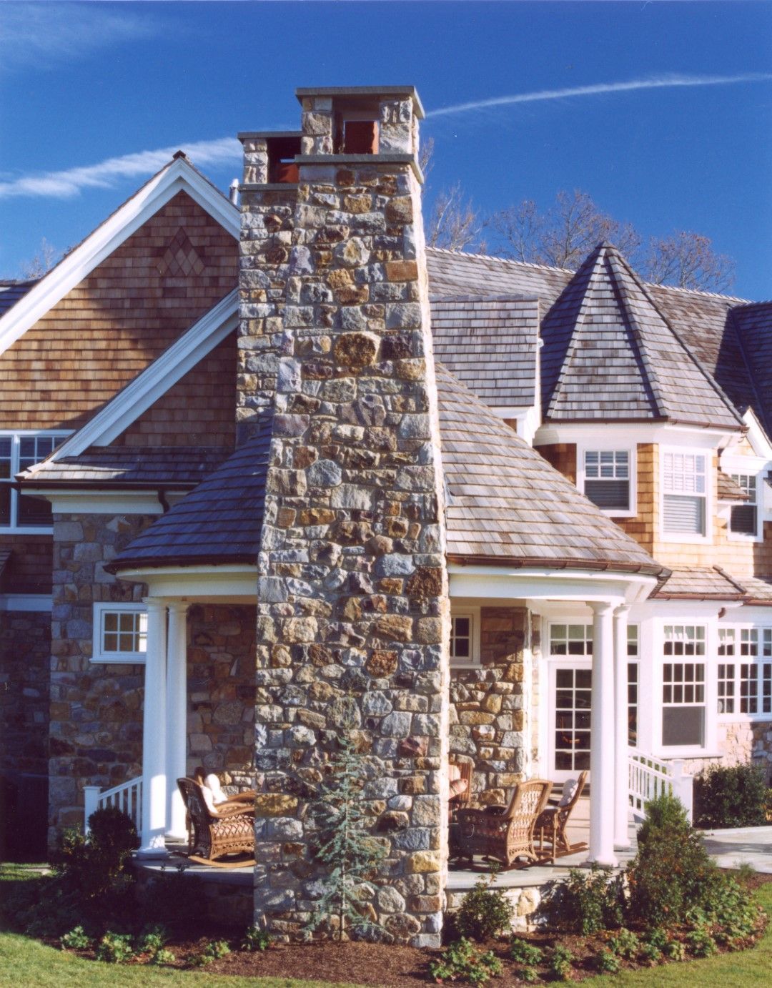 A large stone chimney on the side of a house