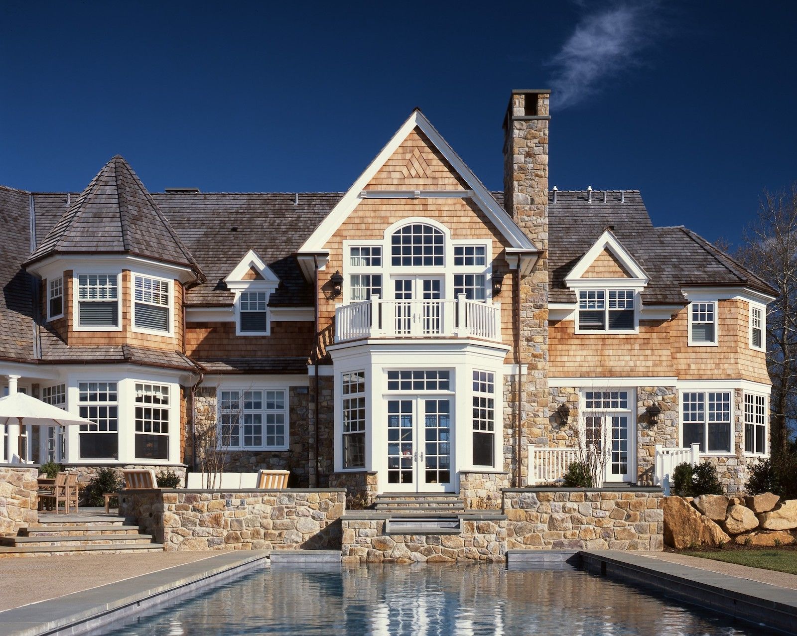 A large house with a swimming pool in front of it