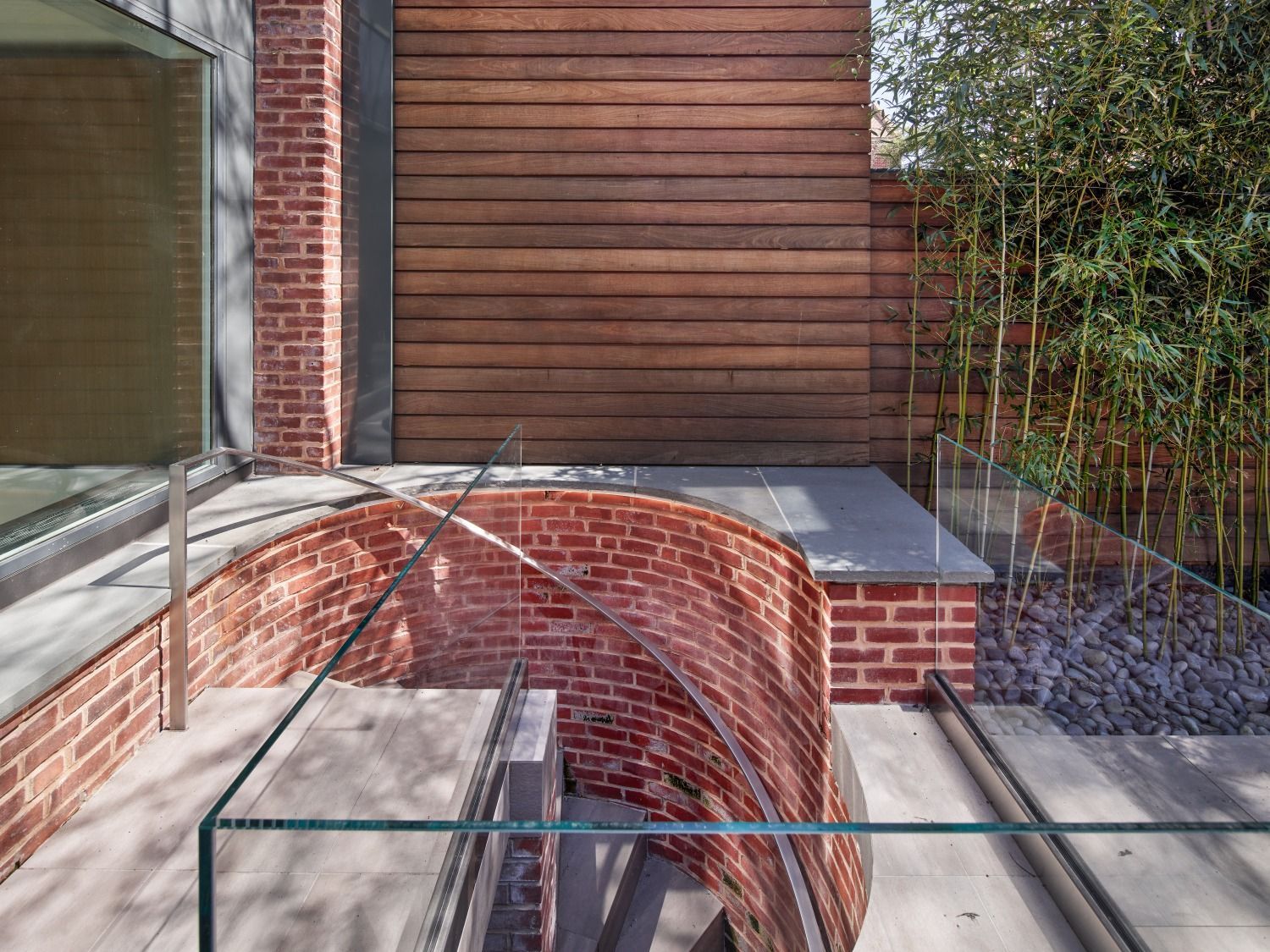 A brick building with a glass railing and stairs