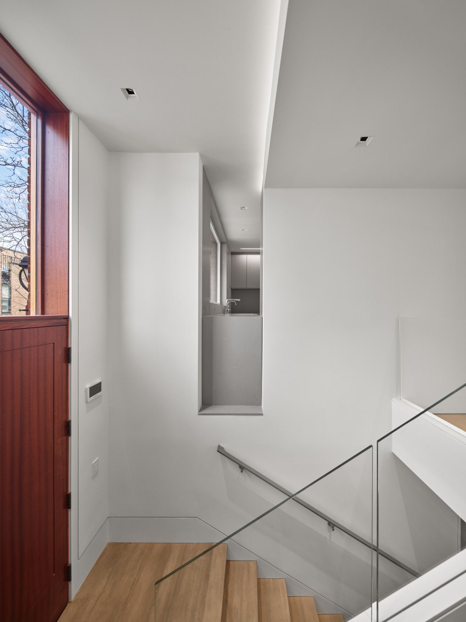A hallway with stairs leading up to the second floor of a house.