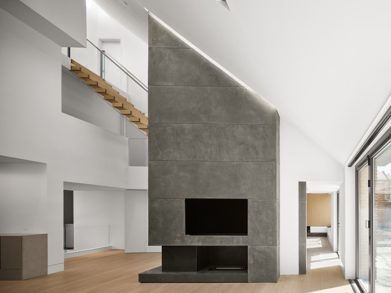 A living room with a fireplace , television and stairs.