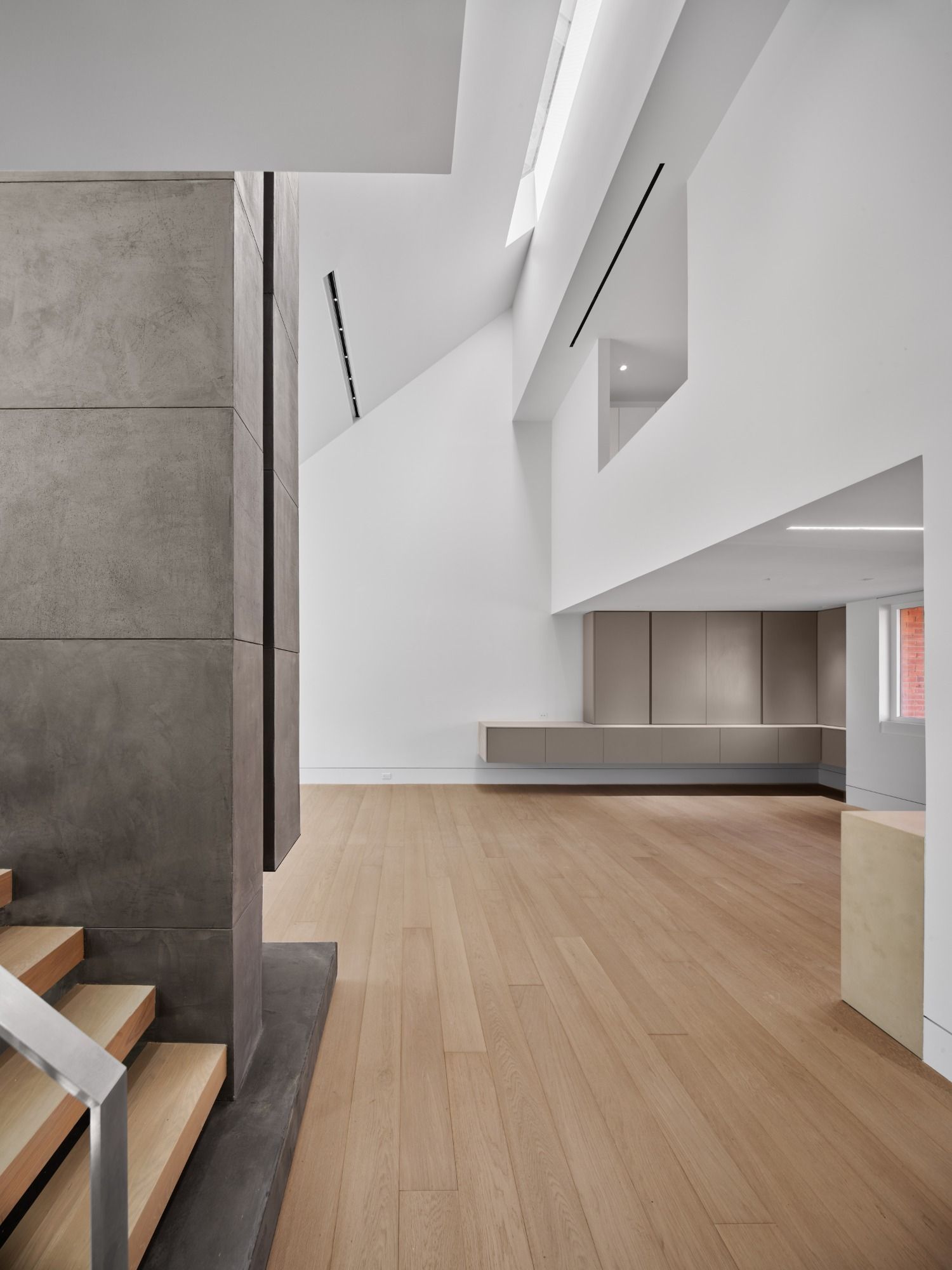 A large room with a wooden floor and stairs