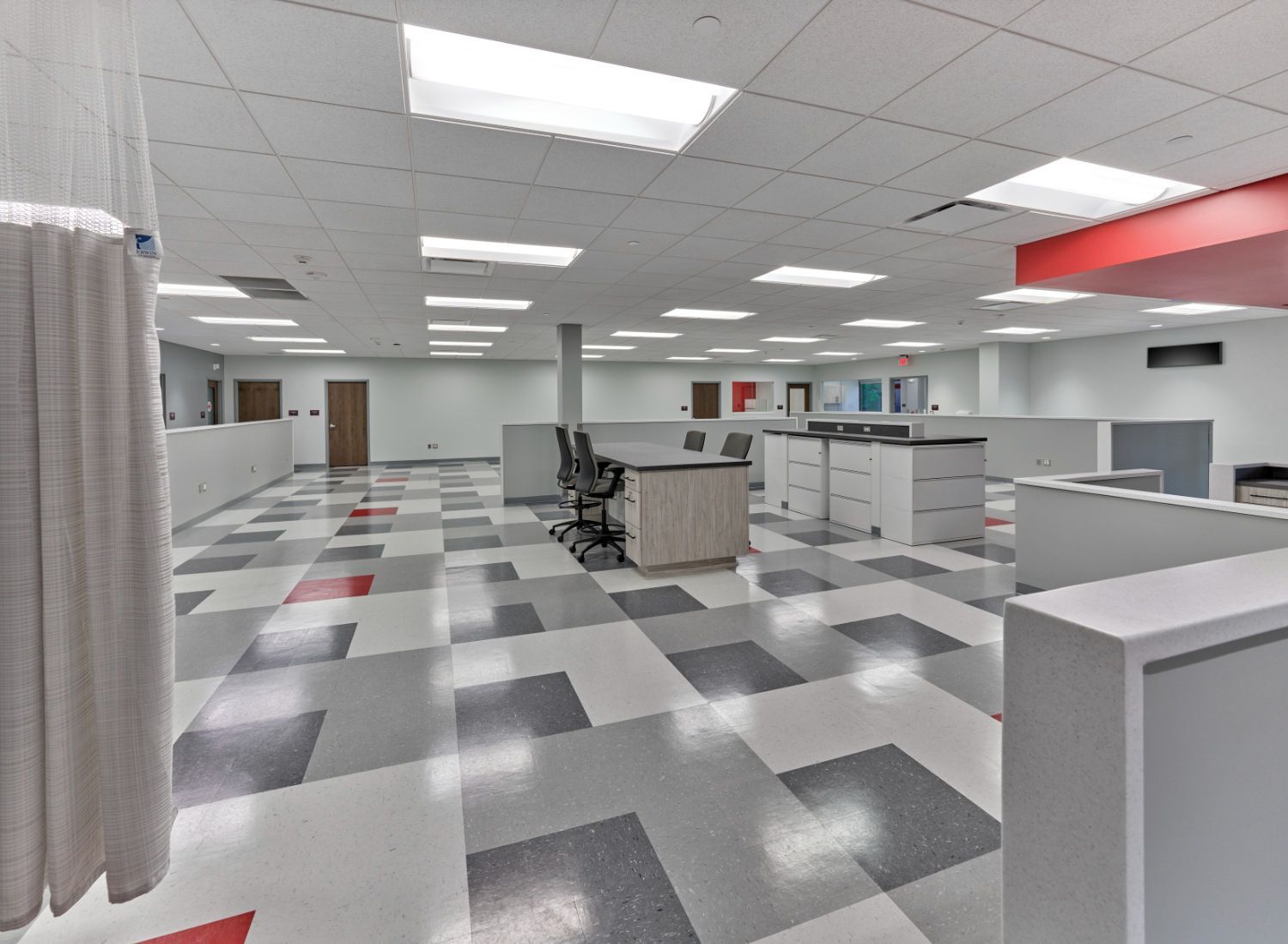 A large room with a checkered floor and cubicles