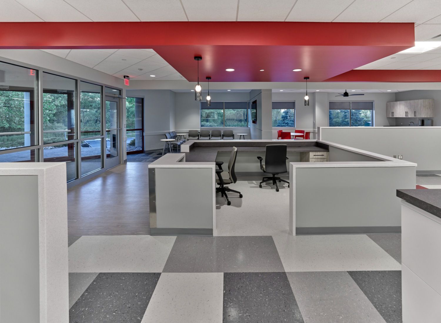 A large room with cubicles and a red ceiling