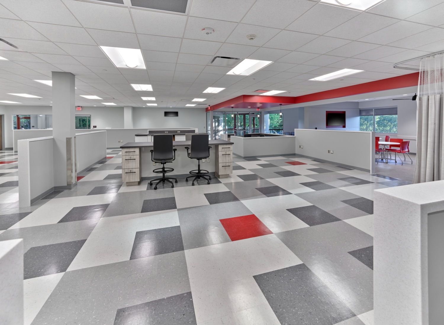A large office with a checkered floor and cubicles