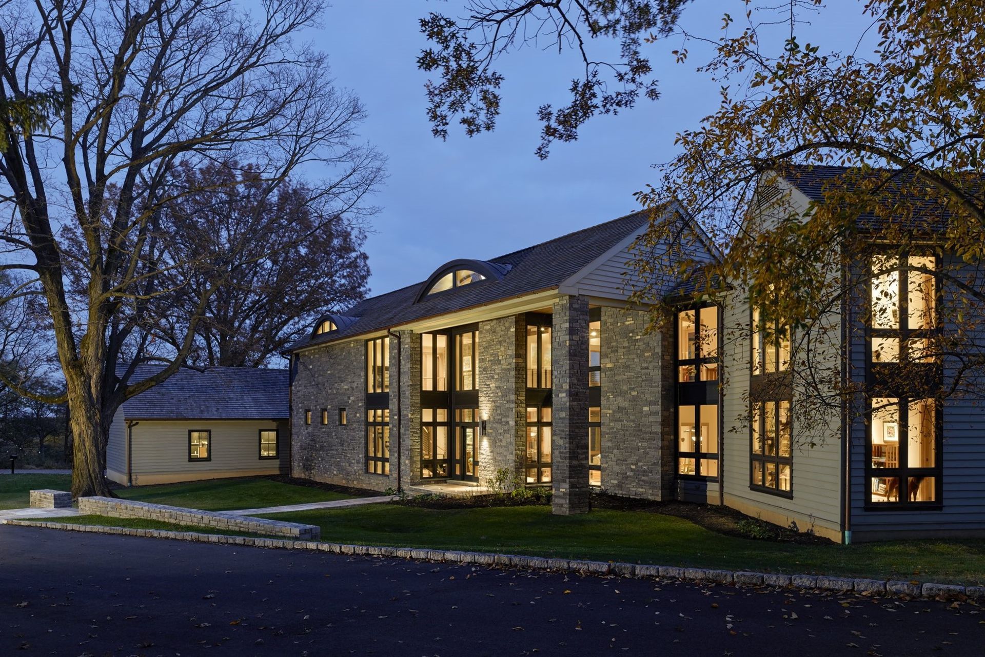 A large house with a lot of windows is lit up at night.
